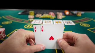 male poker player holding two cards aces Almanbahis Adres